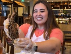 "Pengunjung menikmati hidangan khas dengan penyajian unik di restoran Barelo, Swiss-Belinn Luwuk, dengan senyum puas sambil menikmati makanan laut yang disajikan dengan istimewa."