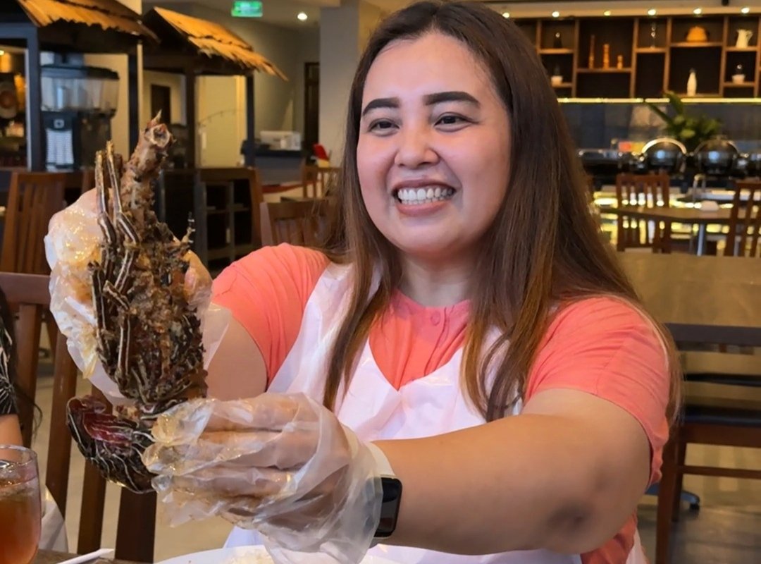 "Pengunjung menikmati hidangan khas dengan penyajian unik di restoran Barelo, Swiss-Belinn Luwuk, dengan senyum puas sambil menikmati makanan laut yang disajikan dengan istimewa."
